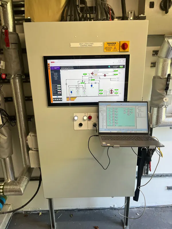 Commissioning a BMS panel with laptop and touchscreen graphics